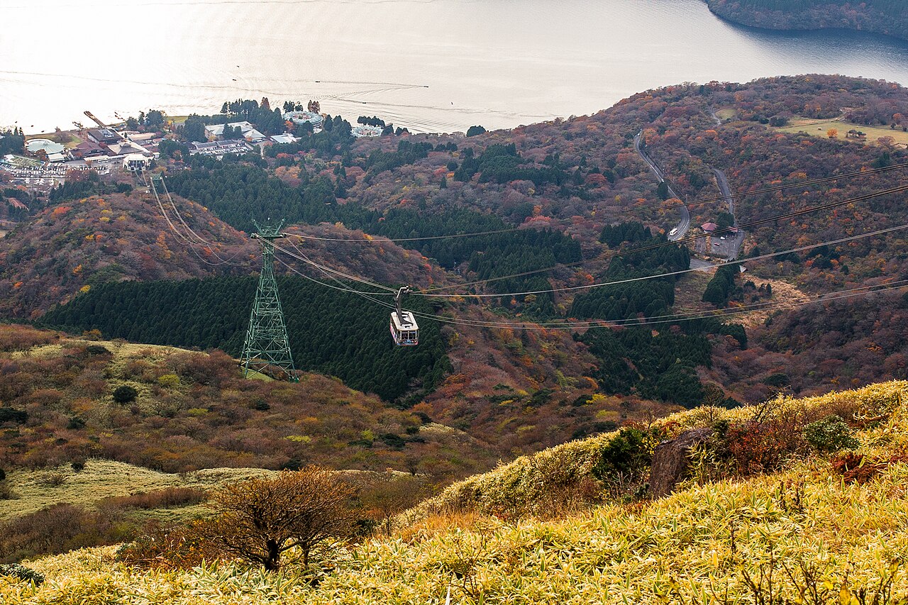 A Hakone Ropeway gondola ascending over volcanic landscape with views of Lake Ashi.