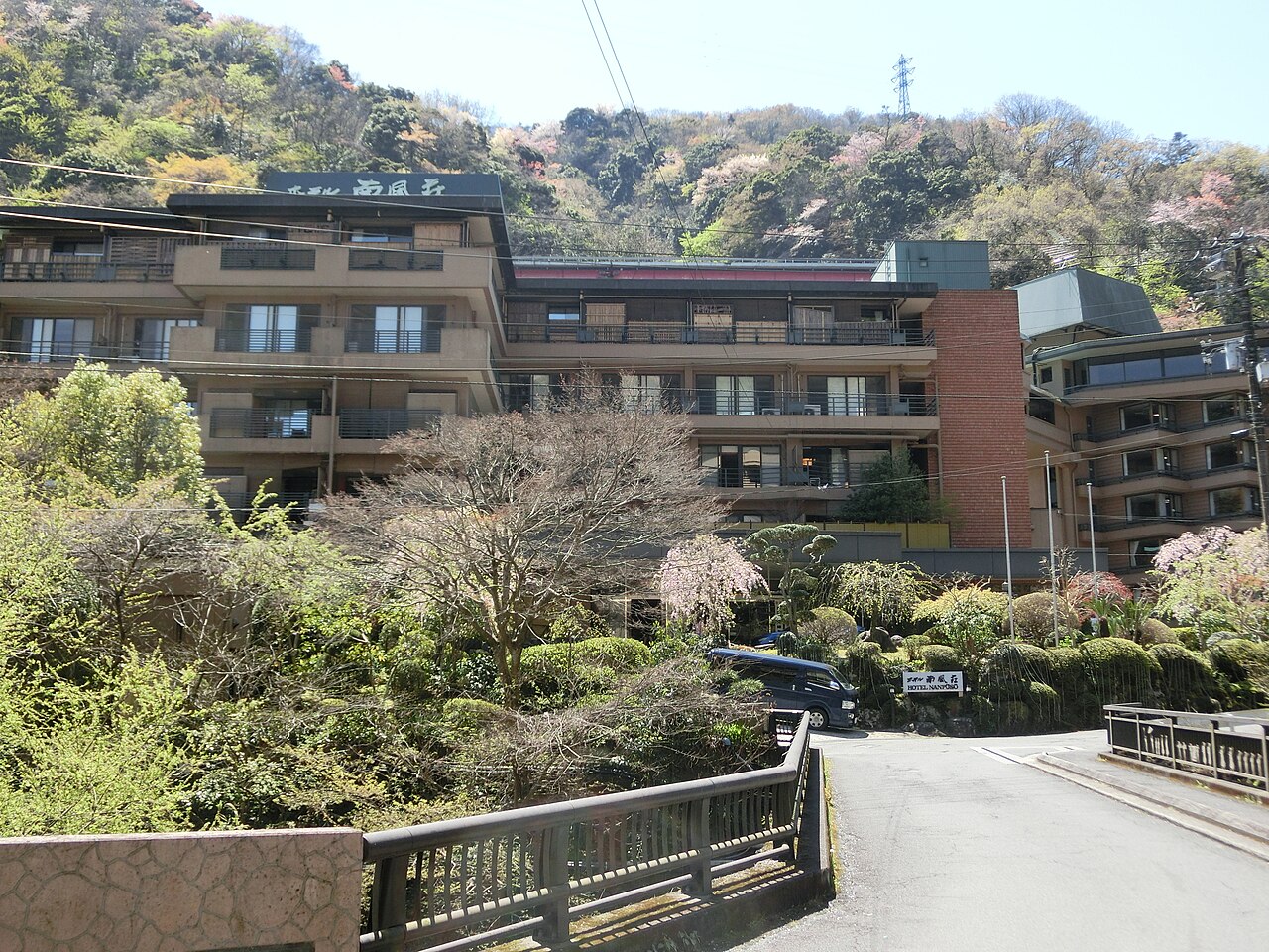 Panoramic view of a Hakone hot spring area with steam rising from the ground and lush greenery