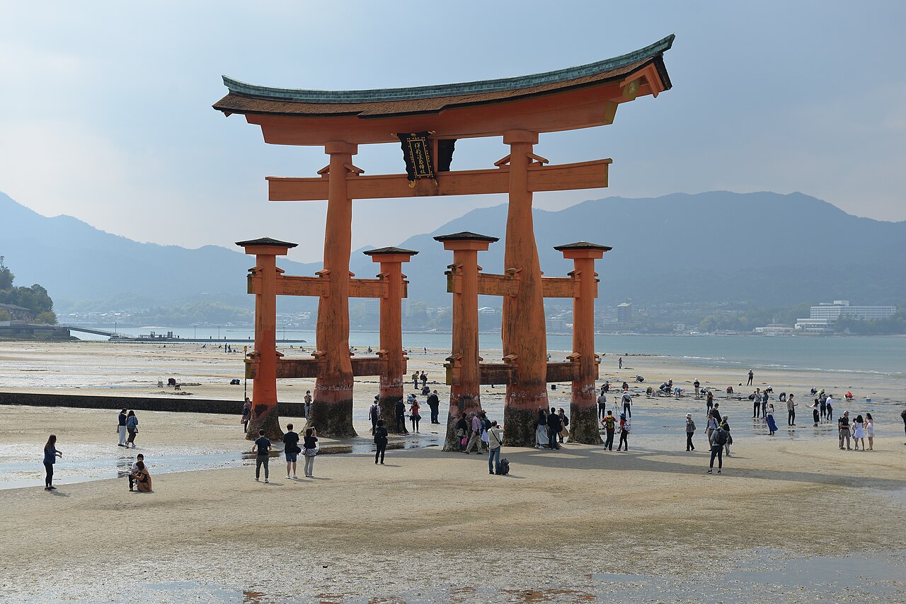 The iconic red torii gate of Itsukushima Shrine appearing to float on the water at high tide on Miyajima Island.