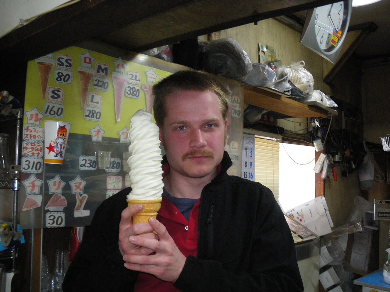 A tall swirl of creamy Hokkaido soft serve ice cream in a cone.