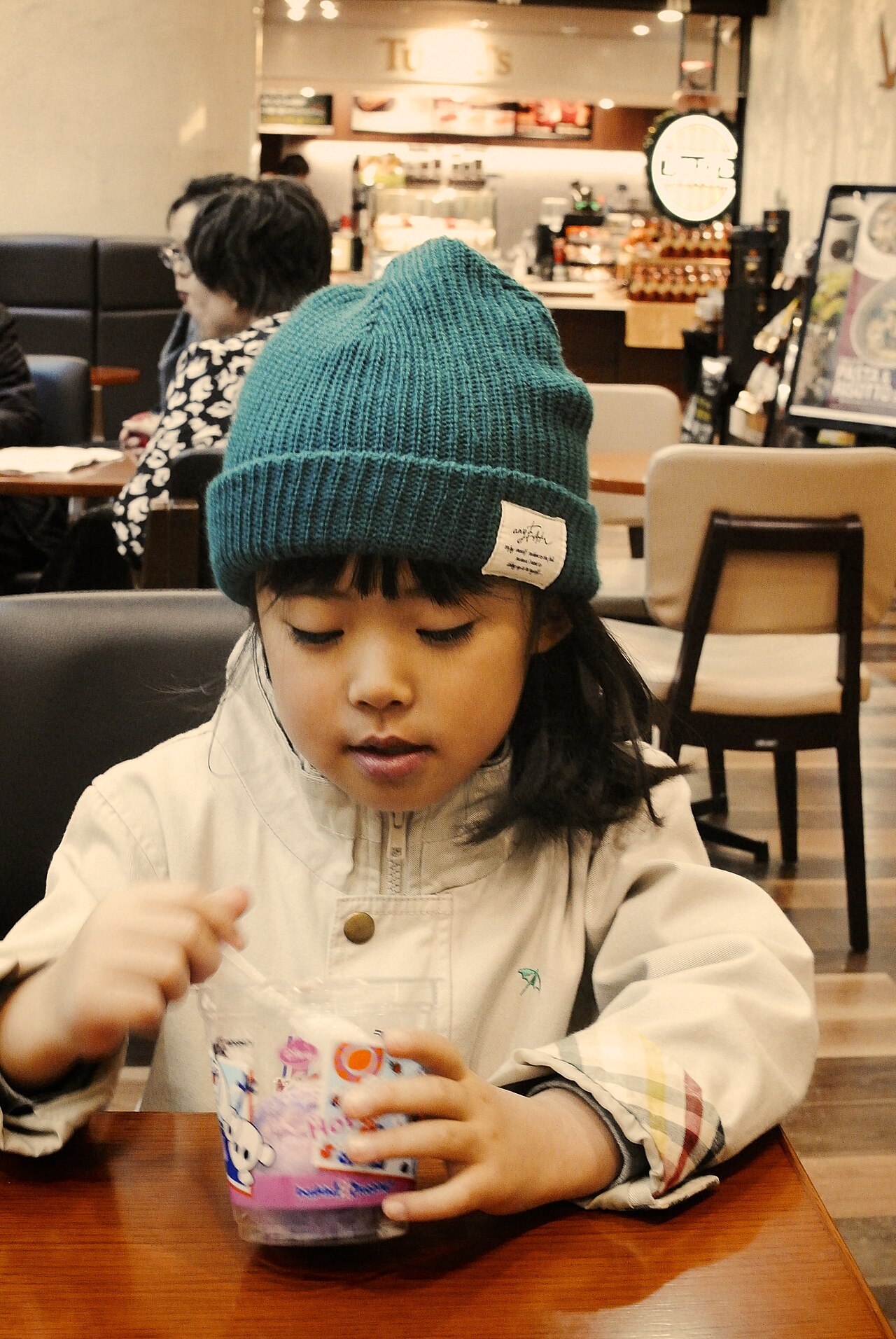 Children laughing while sledding down a snowy hill in Hokkaido.