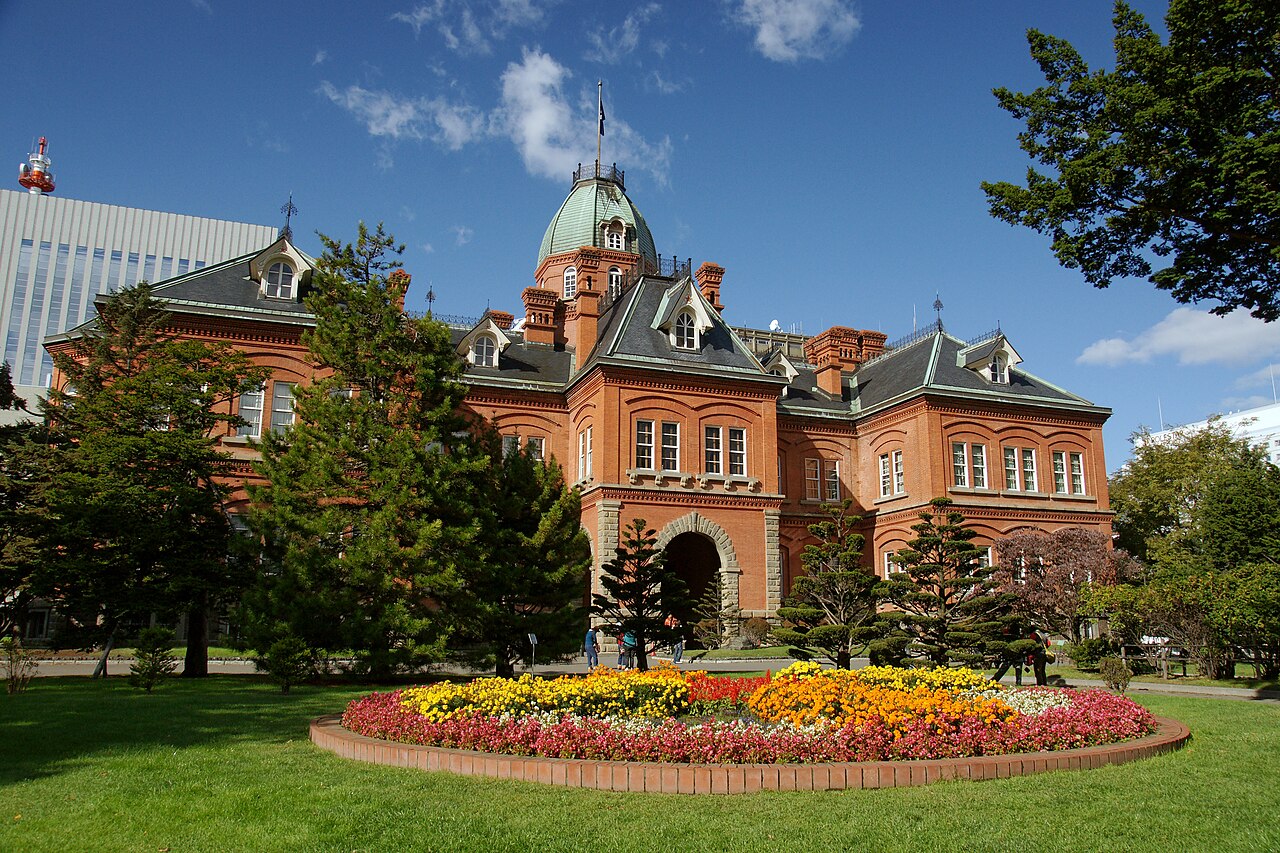 The historic red brick building of the Former Hokkaido Government Office in Sapporo, surrounded by autumn foliage