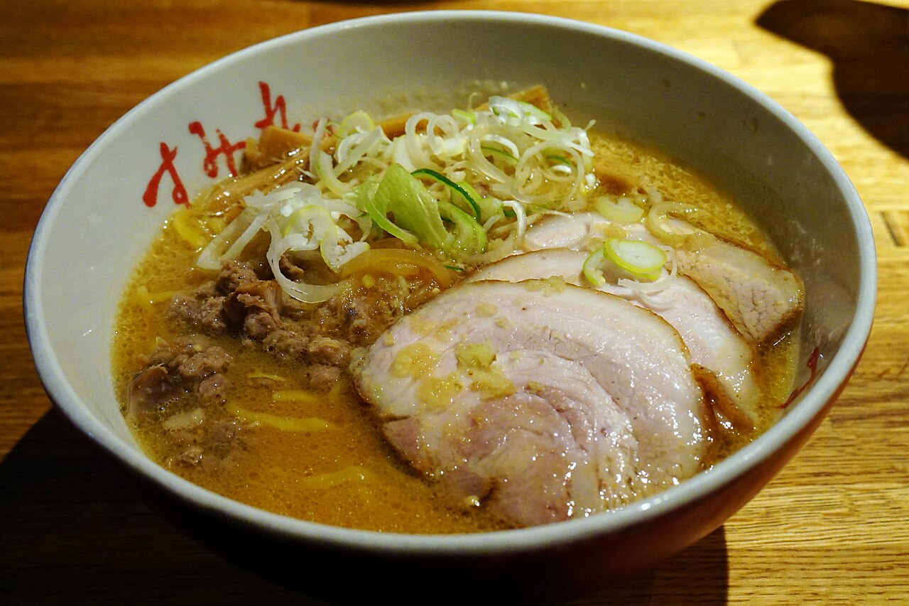 A steaming bowl of Sapporo miso ramen with corn, butter, and chashu pork in Susukino Ramen Alley