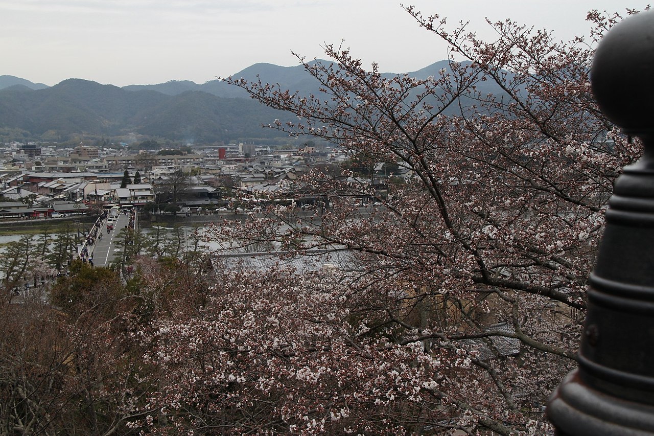 Togetsukyo Bridge spanning the Oi River with vibrant autumn foliage on the surrounding mountains