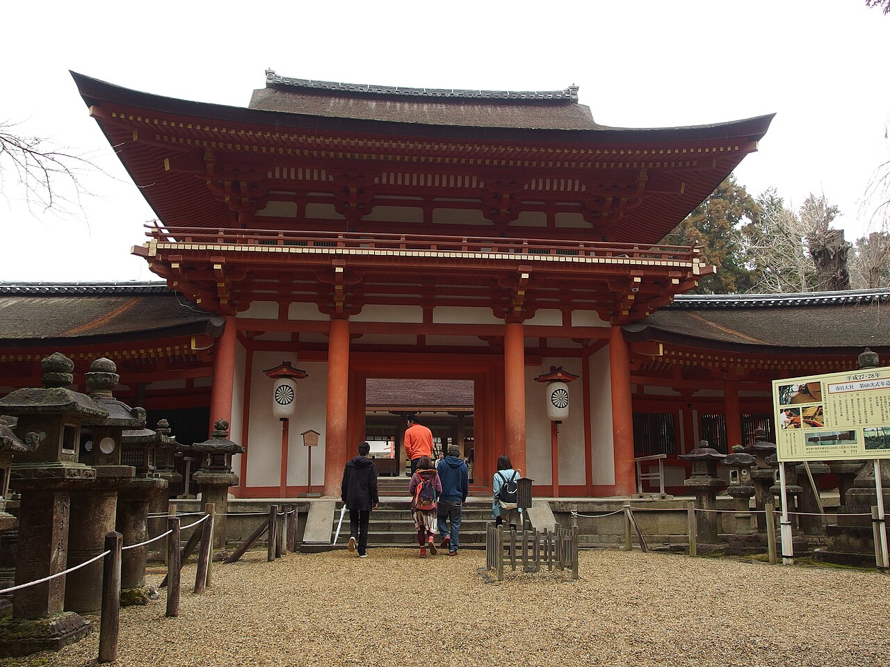 A serene forest path lined with moss-covered stone lanterns leading to Kasuga Taisha Shrine