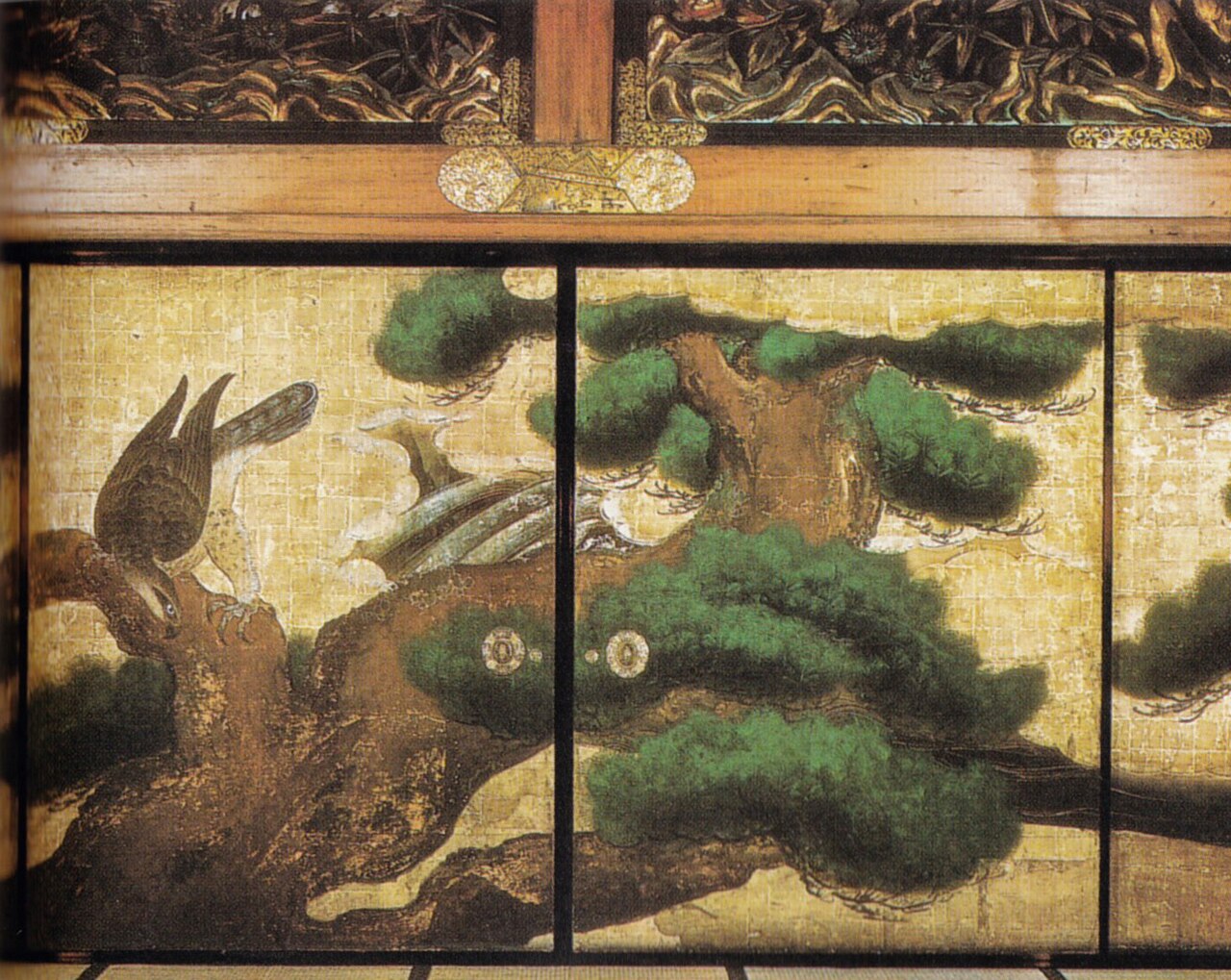 Interior view of Nijo Castle's Ninomaru Palace showing vibrant fusuma sliding door paintings depicting pine trees and birds