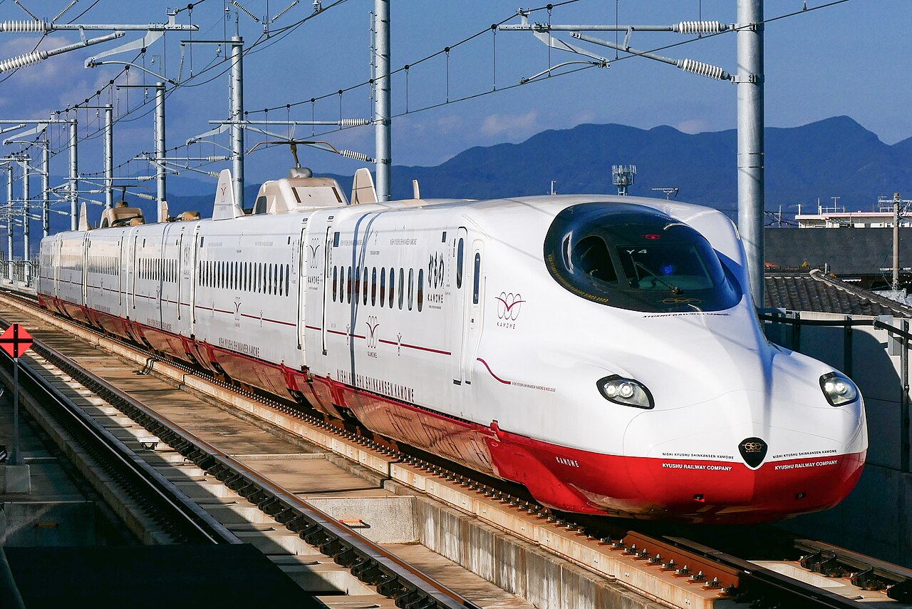 Exterior view of the Kyushu Shinkansen, showcasing its distinctive red and white livery designed by Eiji Mitooka.