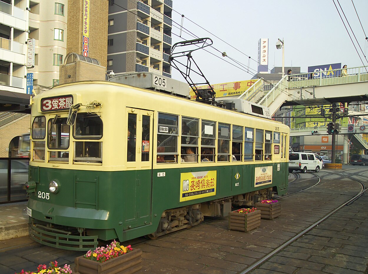 A Nagasaki streetcar traveling through the city streets.