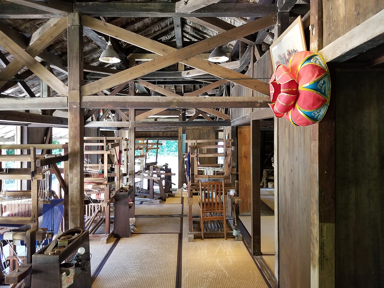 A traditional red-tiled roof Okinawan house with a shisa guardian lion at Ryukyu Mura cultural village
