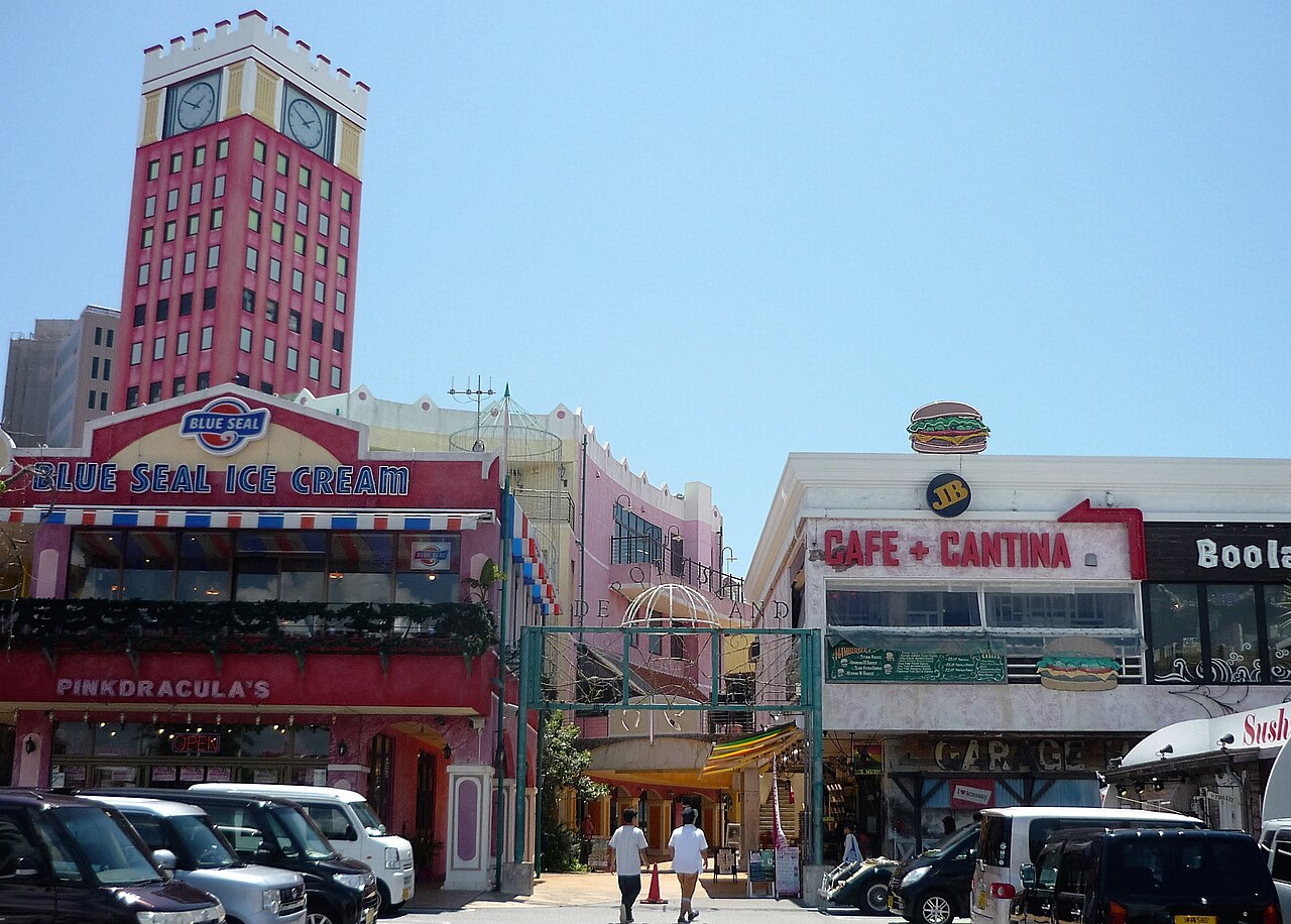 The iconic Ferris wheel lit up at night in Okinawa American Village, reflecting in the water