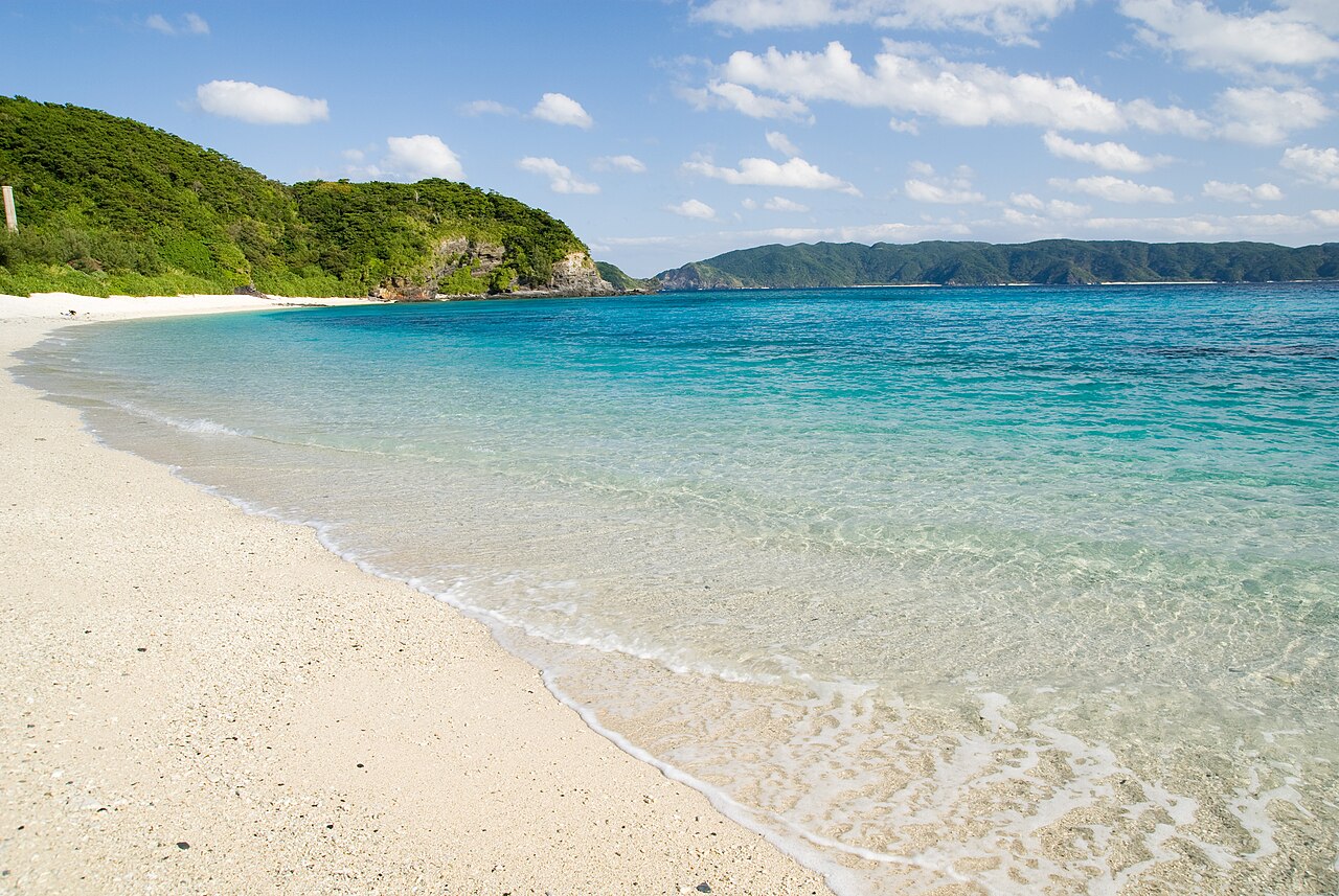 Families with children playing in the shallow, clear waters of Nirai Beach in Okinawa