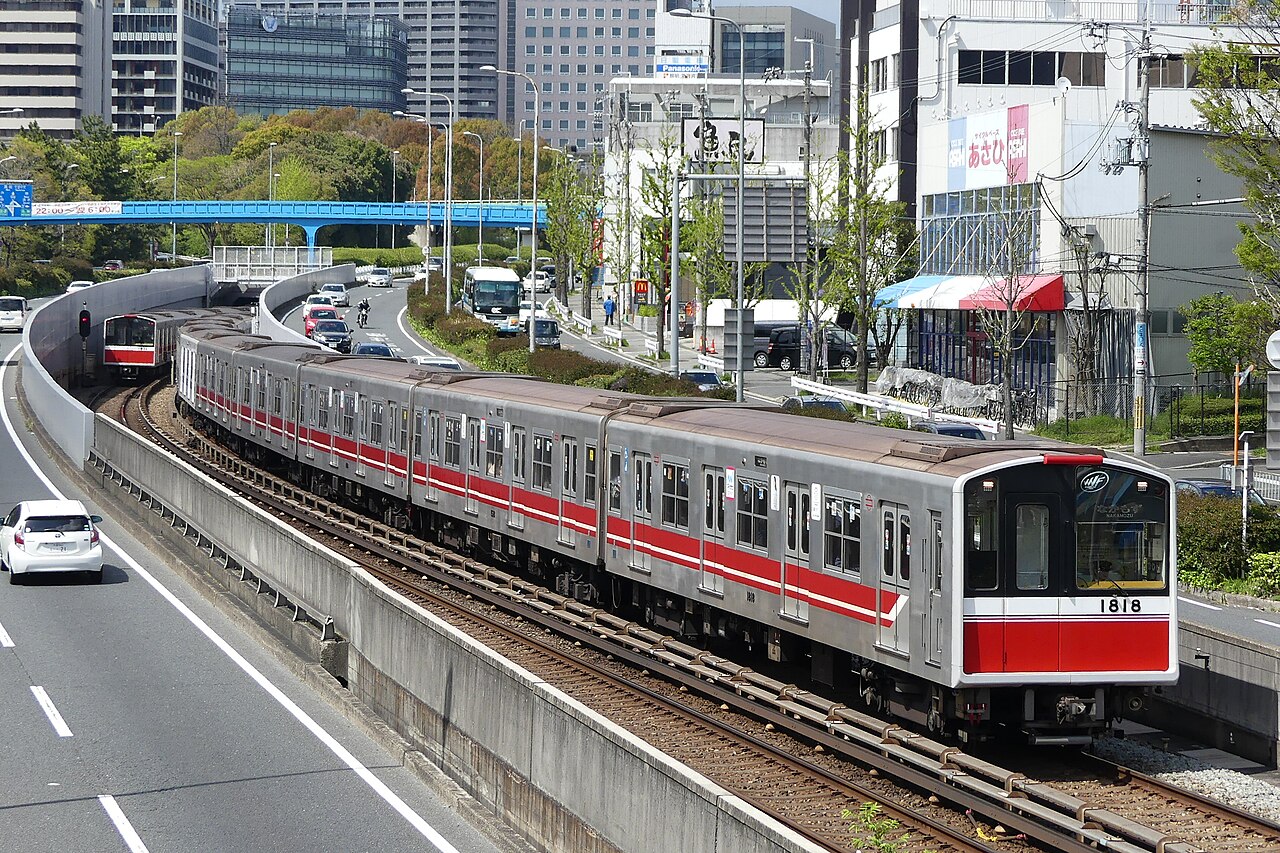 Orange Osaka Metro Midosuji Line train arriving at a station