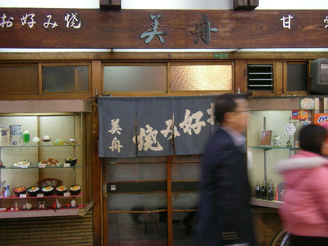 Family enjoying okonomiyaki at a restaurant in Osaka