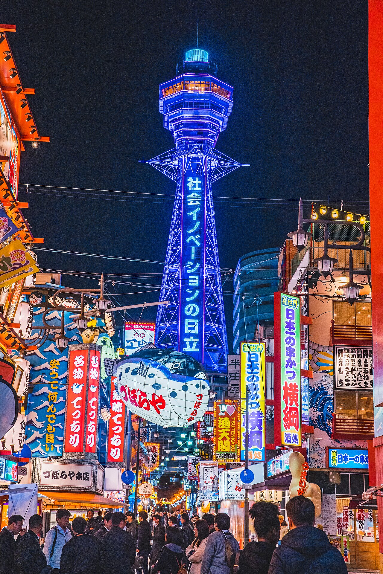 Shinsekai district at night with Tsutenkaku Tower and vibrant neon signs