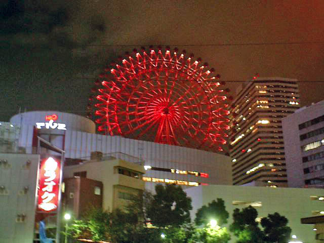 The iconic red Ferris wheel on top of the HEP Five building, illuminated at night in Umeda