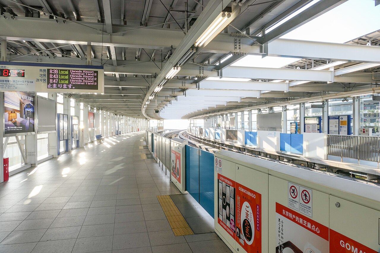 A light blue Tokyo Monorail train arriving at Haneda Airport.