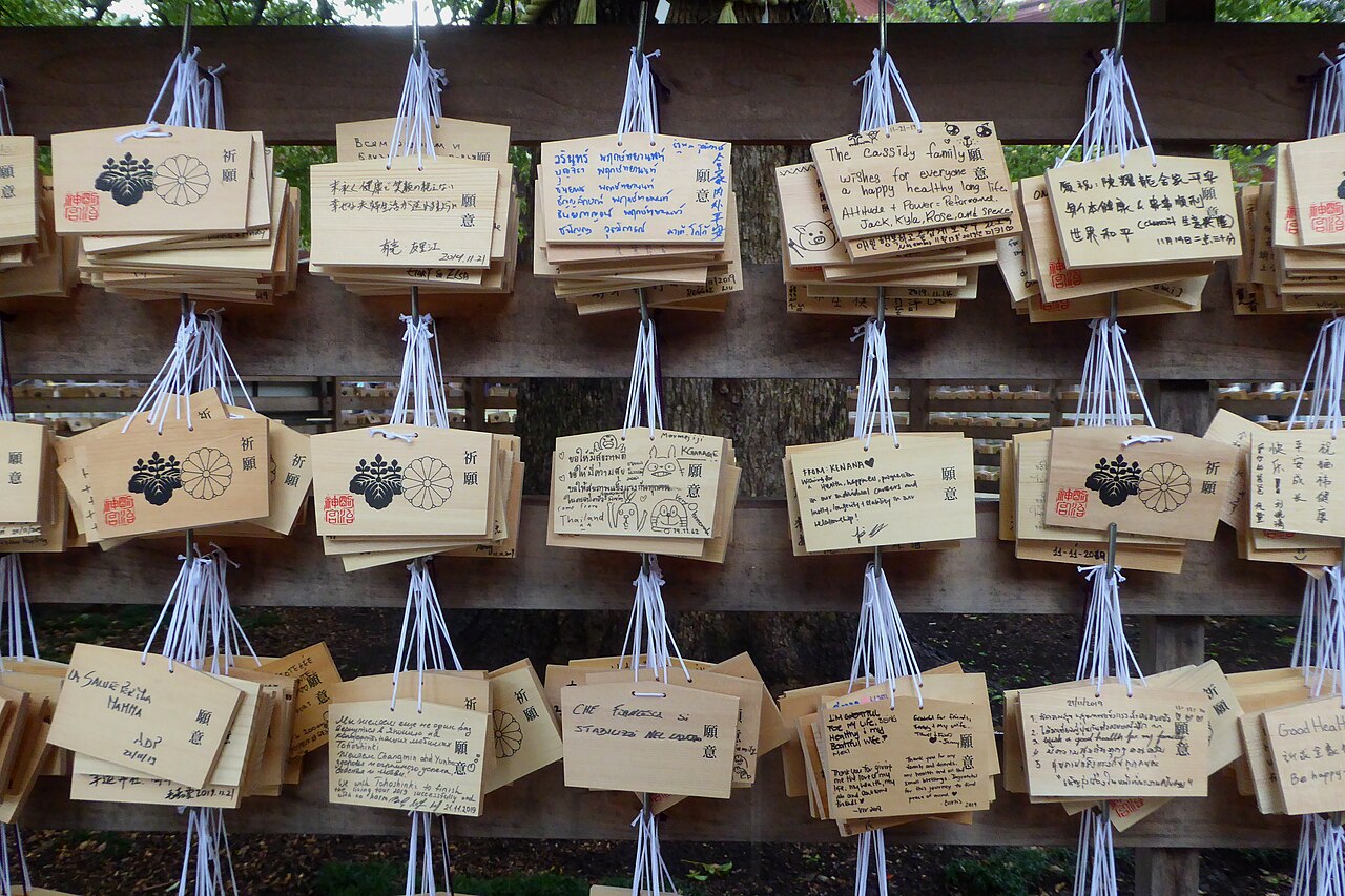 Ema (wooden prayer plaques) hanging at Meiji Shrine, inscribed with visitors' wishes.