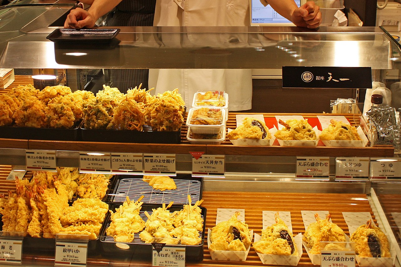 Vibrant display of bento boxes, gourmet foods, and pastries in a bustling Tokyo department store basement food hall (depachika)