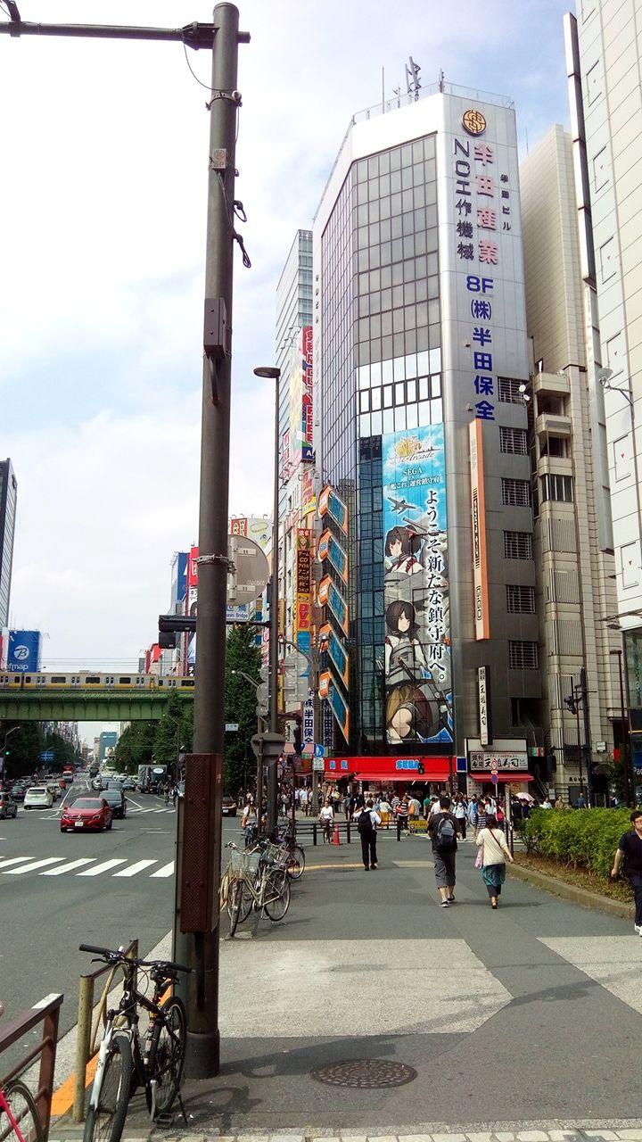 Brightly lit arcade games and visitors inside a multi-story game center in Akihabara, Tokyo