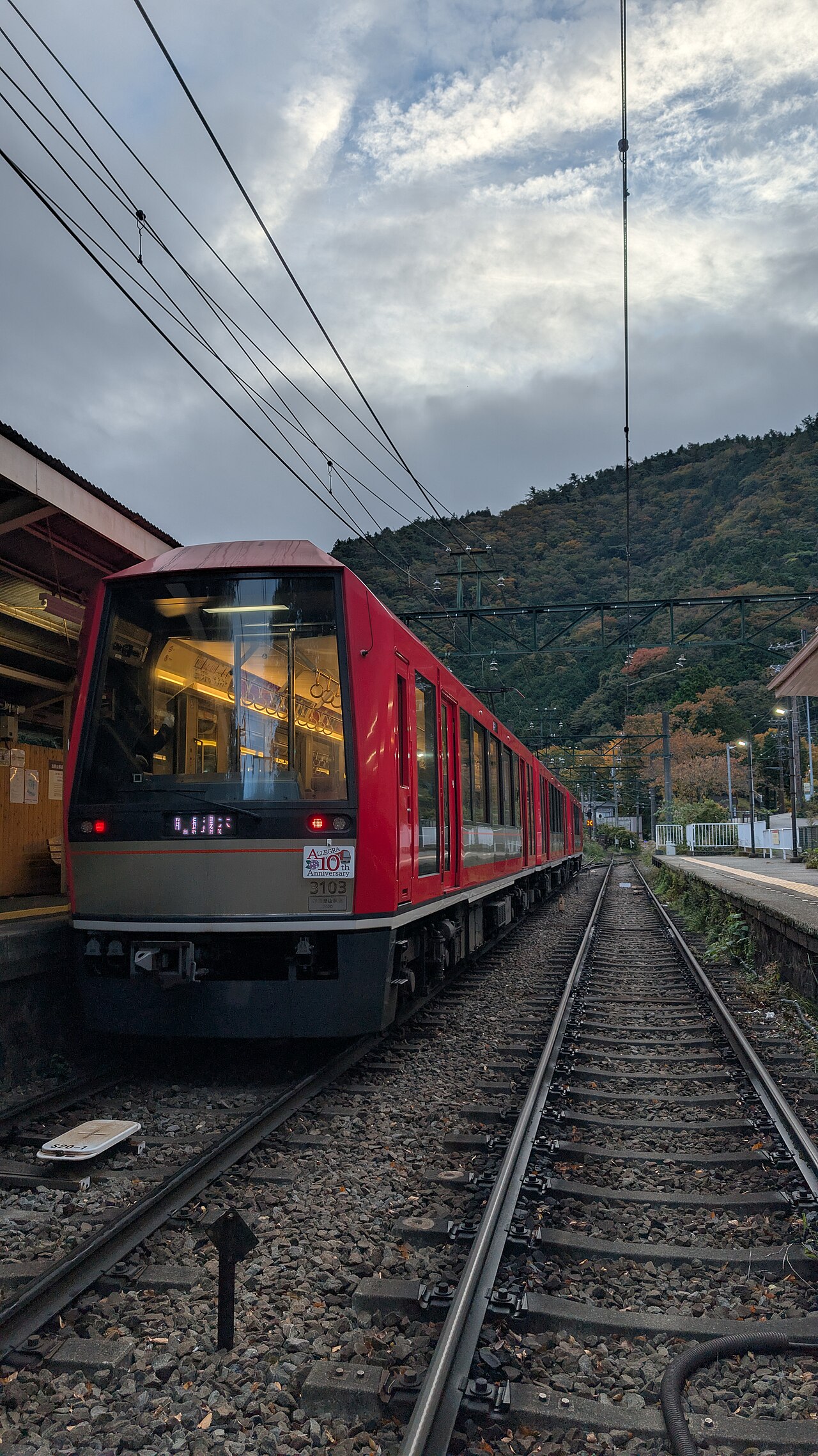 Red Hakone Tozan Railway train winding through lush mountain scenery