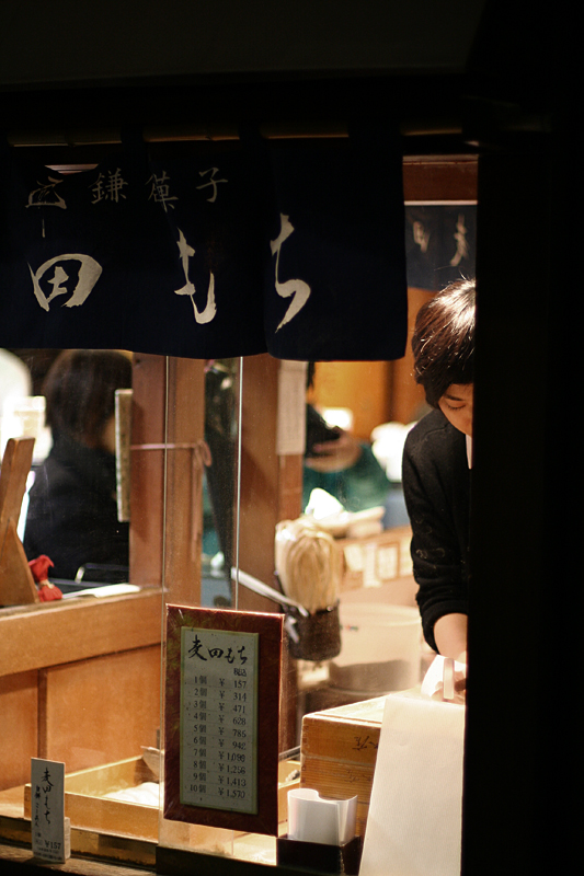 A vibrant Komachi-dori shopping street in Kamakura, lined with shops and pedestrians