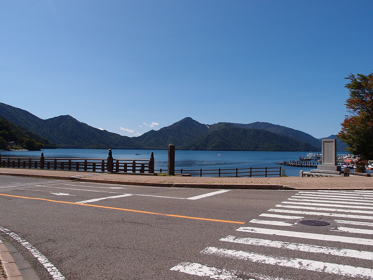 Scenic view of Lake Chuzenji in Nikko, surrounded by mountains with autumn foliage