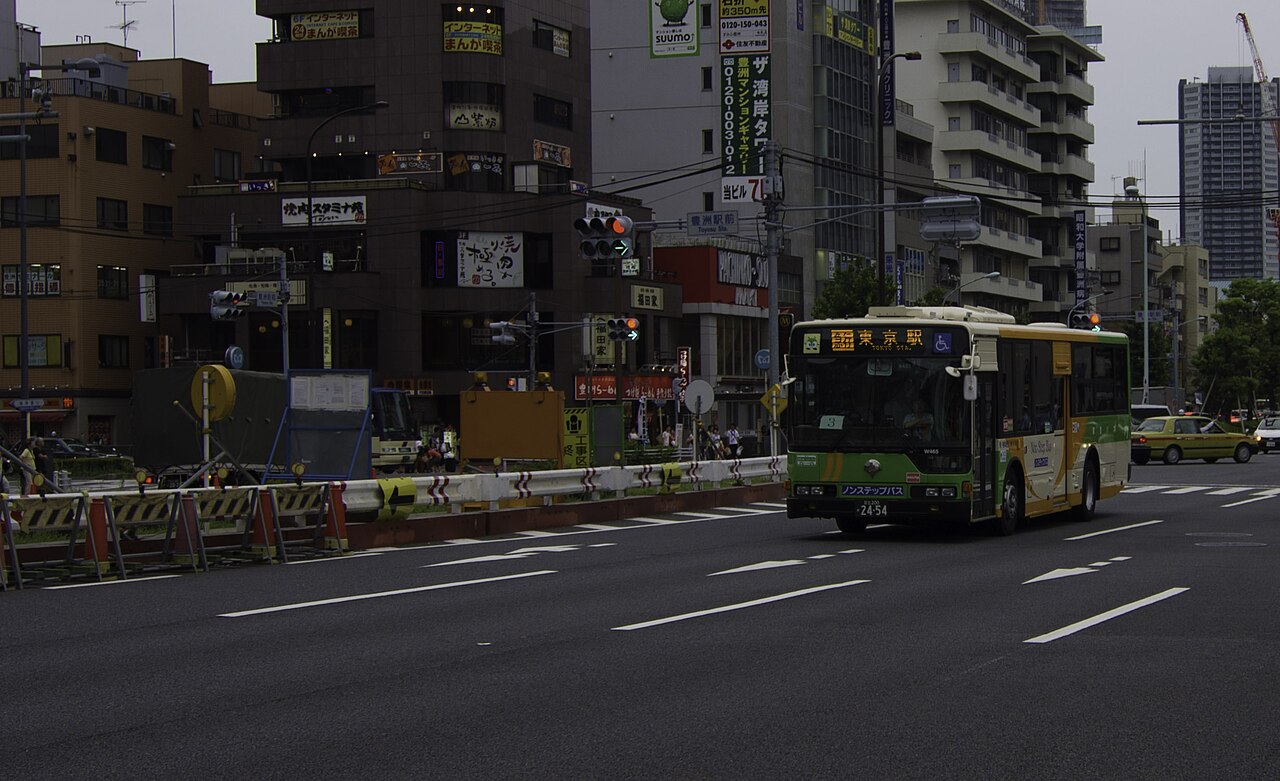 A Toei city bus driving on a street in Tokyo