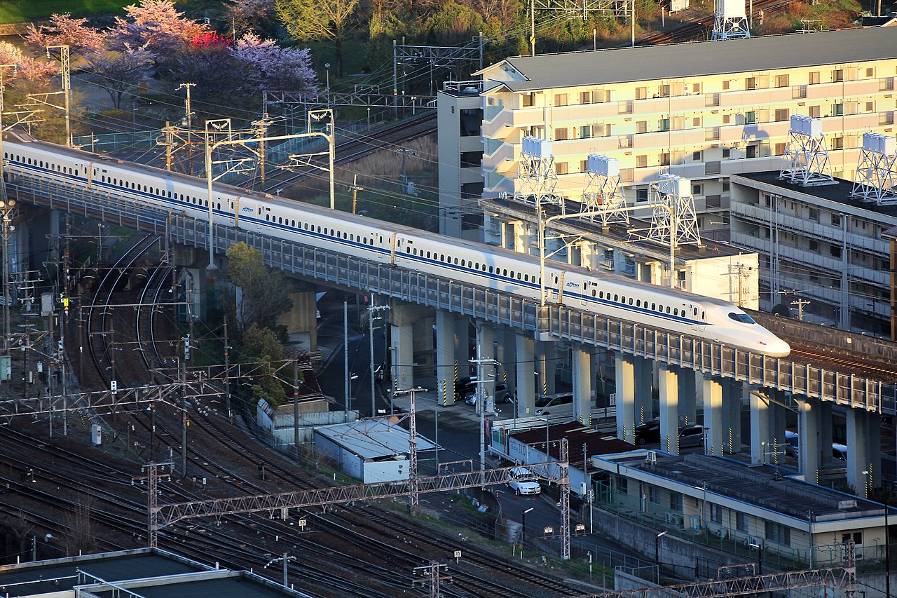 A high-speed Shinkansen bullet train arriving at a station platform