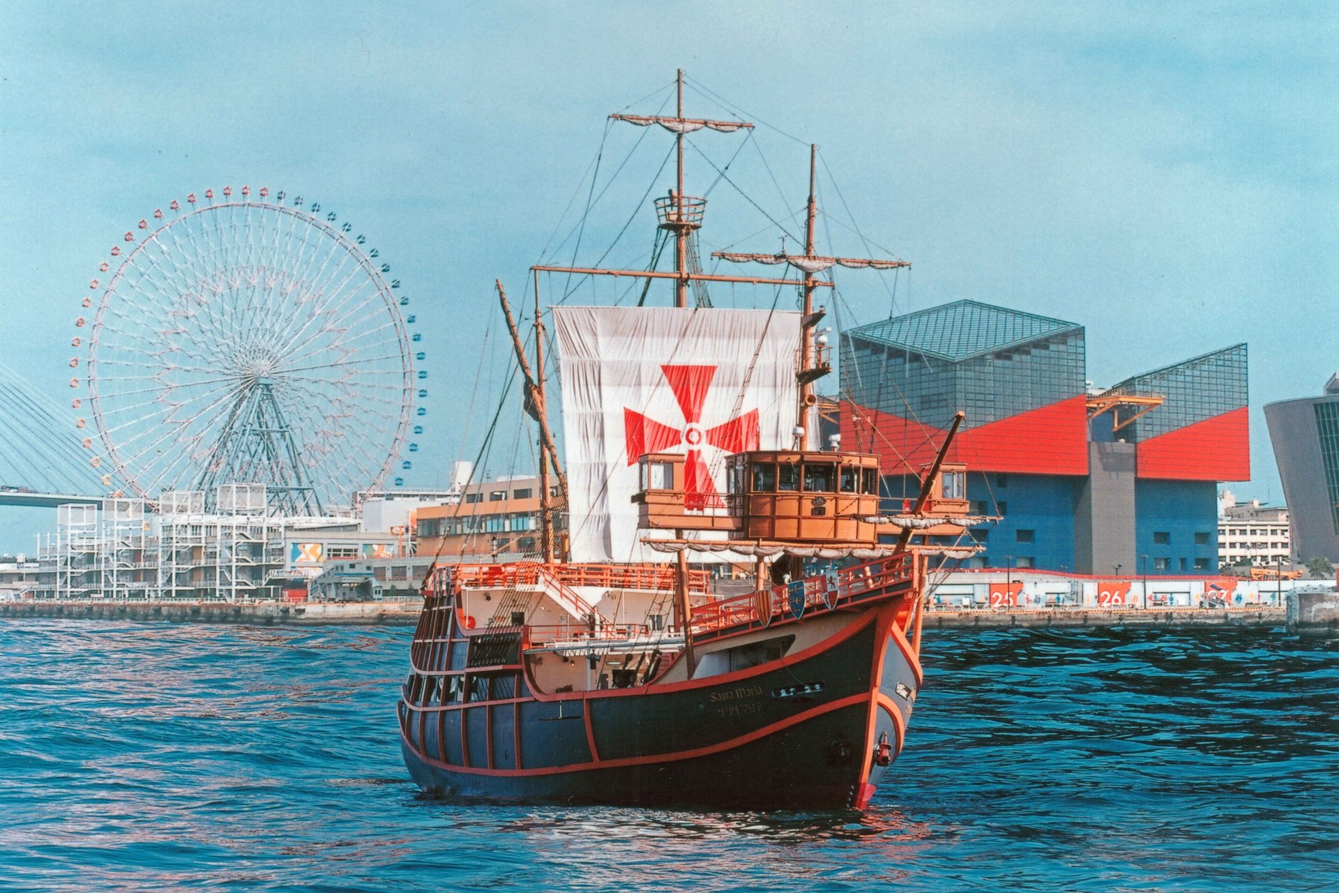 The Santa Maria replica galleon cruising Osaka Bay past the Tempozan Ferris wheel